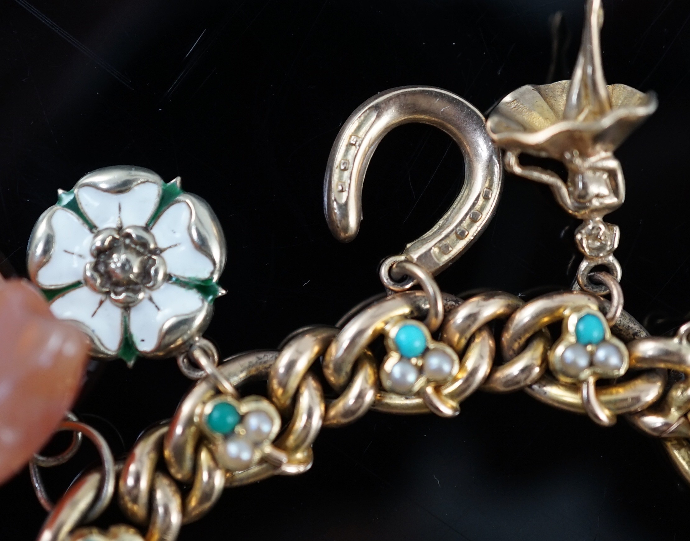 An Edwardian 15ct gold, seed pearl and turquoise set curb link charm bracelet